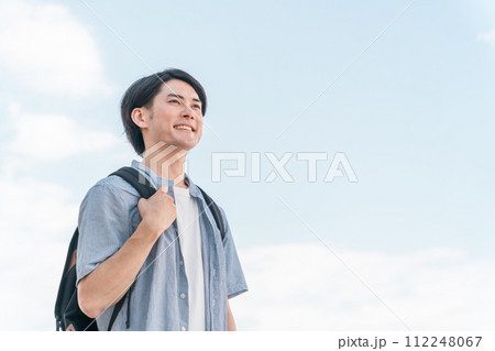 青空の下にいる笑顔の学生・大学生の男性（進学・受験・チャレンジ・希望・目標） 112248067