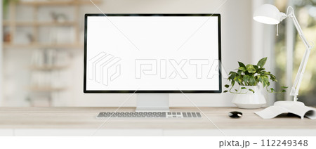 A computer desk in a modern, minimal white home office features a PC computer white-screen mockup. 112249348