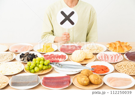 色々な食材とバツサインをするミドル女性 112250039