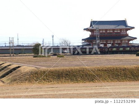 世界遺産の奈良平城宮跡朱雀門の前を走行する近鉄の観光特急「あをによし」 112253299