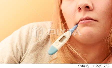 Sick ill woman with digital thermometer in mouth. Sick ill woman with digital thermometer in mouth. 112253735