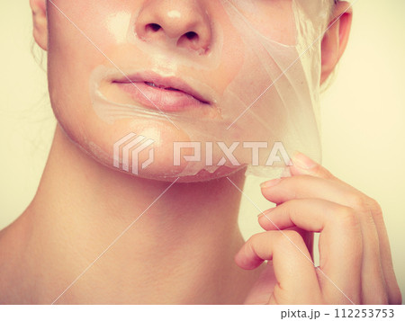 Woman removing facial peel off mask. 112253753