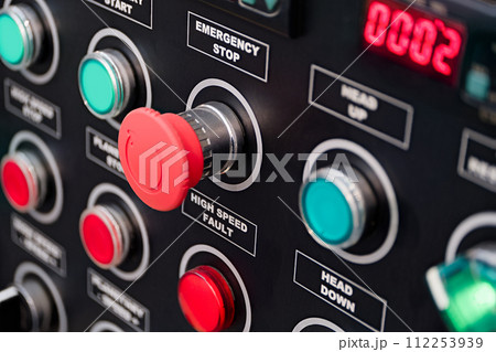 Red and green round lamps and buttons on black control panel 112253939