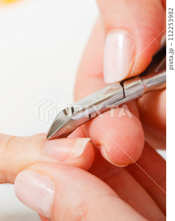Preparing nails before manicure, cutting cuticles 112253982