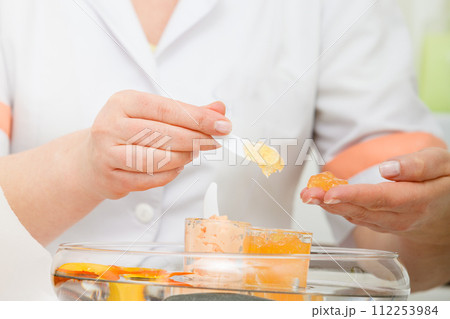 Woman applying cream on hand using spatula Woman applying cream on hand using spatula 112253984