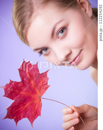 Skin care. Portrait of young woman girl with red maple leaf. Skin care. Portrait of young woman girl with red maple leaf. 112254292