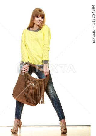 woman holds brown fringe handbag woman holds brown fringe handbag 112254294