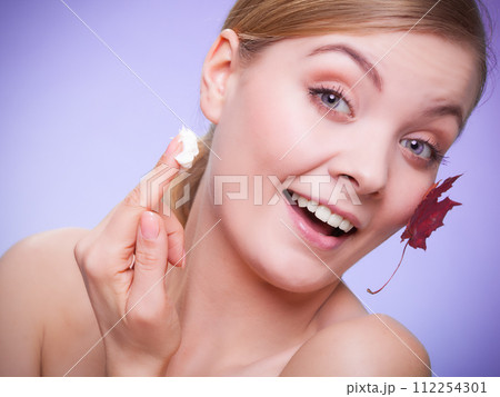 Skin care. Face of young woman girl with red maple leaf. 112254301