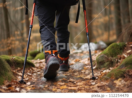 Hiker with trekking sticks walking the trail and climbing the mountain. Generative Ai image Hiker with trekking sticks walking the trail and climbing the mountain. Generative Ai image 112254470