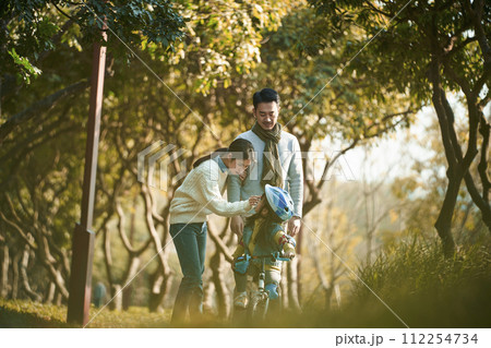 asian parents taking care of child outdoors in park 112254734