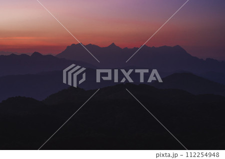 nature traveling with orange sky and layer of mountain with sunrise background 112254948