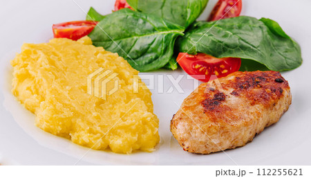 polenta with cutlet and cherry tomatoes with basil polenta with cutlet and cherry tomatoes with basil 112255621