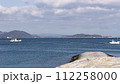静かな海と雲のある空と行きかう船が見える風景 112258000