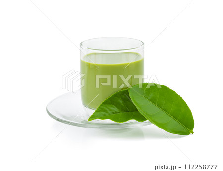 Hot green tea matcha latte with powdered green tea and tea leaves isolated on white background. Hot green tea matcha latte with powdered green tea and tea leaves isolated on white background. 112258777