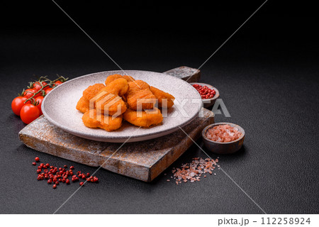 Delicious fresh crispy chicken nuggets on a dark concrete background 112258924
