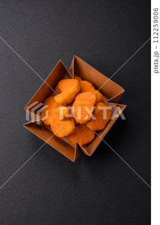 Delicious fresh crispy chicken nuggets on a dark concrete background 112259006