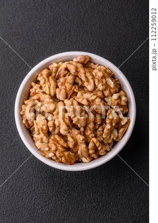 Delicious fresh peeled raw walnuts in a ceramic plate Delicious fresh peeled raw walnuts in a ceramic plate 112259012