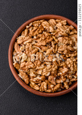 Delicious fresh peeled raw walnuts in a ceramic plate Delicious fresh peeled raw walnuts in a ceramic plate 112259025