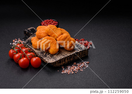 Delicious fresh crispy chicken nuggets on a dark concrete background 112259050