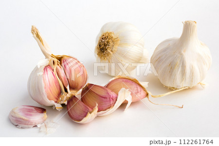 Garlic heads and cloves on white background Garlic heads and cloves on white background 112261764