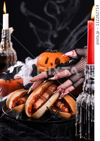 Bloody hot dog in the hands of a witch Bloody hot dog in the hands of a witch 112262714