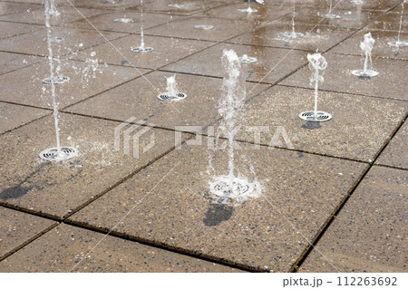 Water droplets spread from the fountain in the air. Splashing water from a fountain in the park Water droplets spread from the fountain in the air. Splashing water from a fountain in the park 112263692