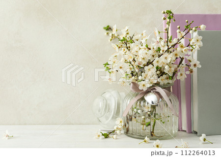 Spring twigs with flowers in a jar, with books on a light background. Spring twigs with flowers in a jar, with books on a light background. 112264013