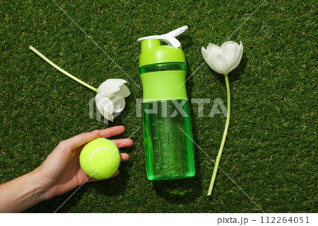Green bottle for water, with flowers on a green background. 112264051