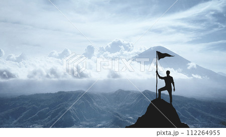 Silhouette of a man on the peak of a mountain, concept of victory and achievement 112264955