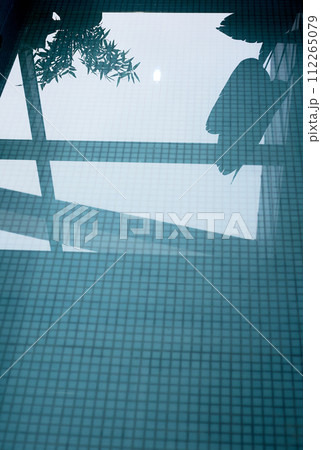 Blue water in the pool with mosaic tiles. Reflection of flowers in the water Blue water in the pool with mosaic tiles. Reflection of flowers in the water 112265079