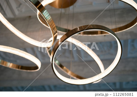 Chandelier on the concrete ceiling. Circles or rings. Luminaire design Chandelier on the concrete ceiling. Circles or rings. Luminaire design 112265081