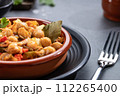Close up. Ropa vieja, typical Canarian dish of chickpeas stew on earthenware casserole on dark base. 112265400