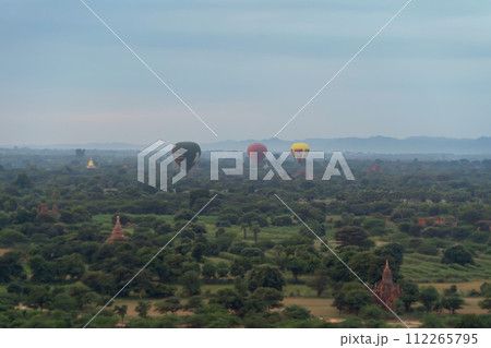 Balloons flying over Burmese temples of Bagan City from a balloon, unesco world heritage with forest trees, Myanmar or Burma. Tourist destination. Balloons flying over Burmese temples of Bagan City from a balloon, unesco world heritage with forest trees, Myanmar or Burma. Tourist destination. 112265795