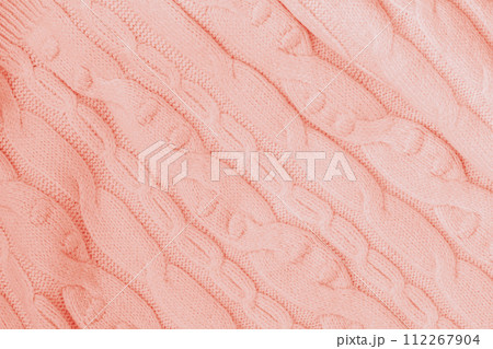 Knitted texture, Coral color with pattern, woolen knit fabric closeup. Background 112267904