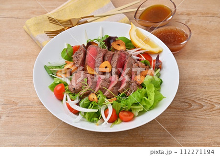 ボリューミーなステーキサラダ、野菜サラダ、牛モモ肉のステーキ、ドレッシング添え。 ボリューミーなステーキサラダ、野菜サラダ、牛モモ肉のステーキ、ドレッシング添え。 112271194
