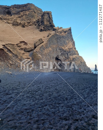 Huge basalt rocks on reynisfjara beach, icelandic rock formations stacked in blocks on reynisfjall mountain. Majestic unique nature creating beautiful scenery, black sand beach in iceland. 112271487