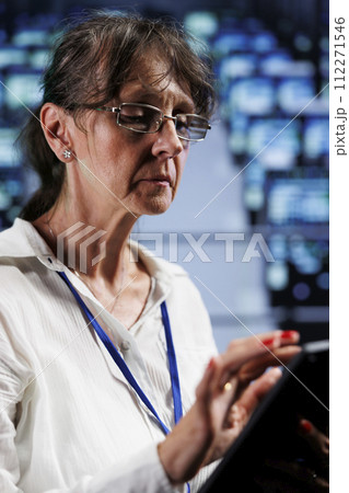 Seasoned wireman preparing cloud computing business recovery plan, monitoring data center energy consumption across parts, making sure sensors are in ideal condition, doing annual disk checks 112271546