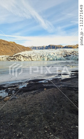Massive Vatnajokull glacier cap in Iceland with diamond shape rocks and transparent blocks of ice painted white and blue. Nordic frozen hills covered in frost, cold water within icelandic scenery. Massive Vatnajokull glacier cap in Iceland with diamond shape rocks and transparent blocks of ice painted white and blue. Nordic frozen hills covered in frost, cold water within icelandic scenery. 112271649