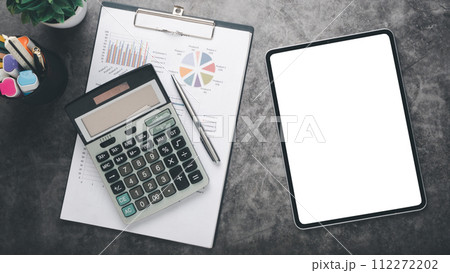 Tablet with charts and reports on office desk workplace. Top view flat lay 112272202
