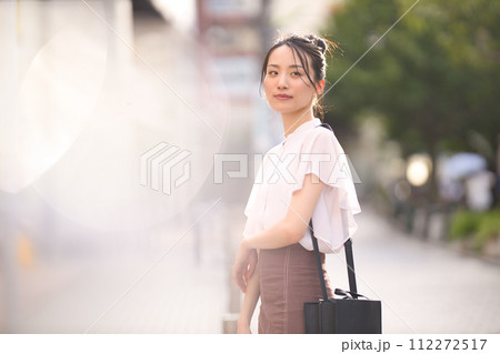 夕暮れの街でショッピングを楽しむ若い女性 112272517