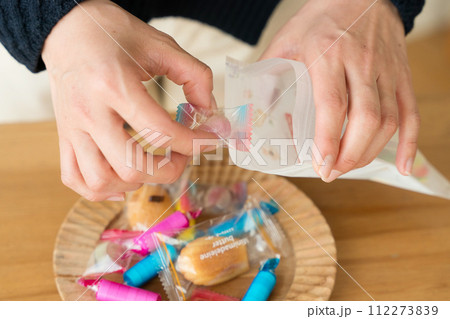 お菓子を袋に入れる女性の手元 お菓子を袋に入れる女性の手元 112273839
