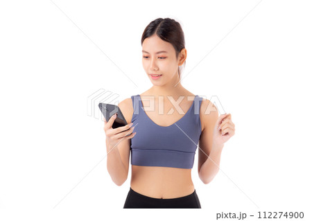 A fit young asian woman in sportswear using a smart phone. A fit young asian woman in sportswear using a smart phone. 112274900