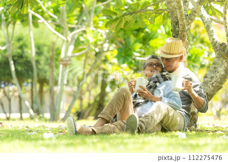 Asian senior elderly retire couple drinking coffee in the nature park happy and relax time. Asian senior elderly retire couple drinking coffee in the nature park happy and relax time. 112275476
