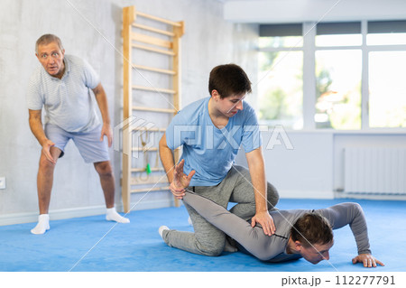 Adult and young men training self-defense techniques 112277791