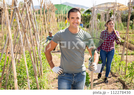 Portrait of latino farmer in his garden with rake 112278430