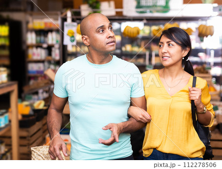 Portrait of happy couple in supermarket interior Portrait of happy couple in supermarket interior 112278506
