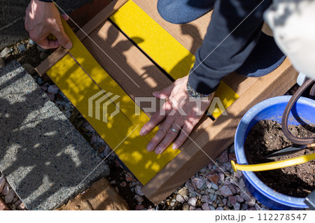 ウッドデッキスループの滑り止めを付ける男性 112278547