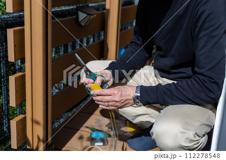 ウッドデッキスループの滑り止めを付ける男性 112278548