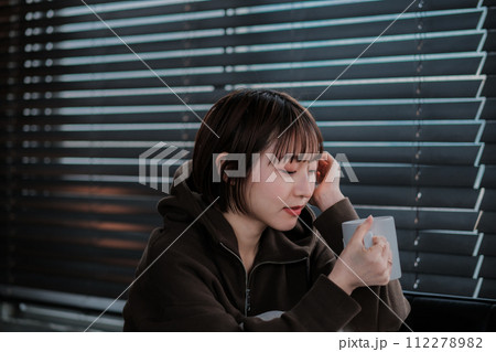 部屋着でソファーに座ってスマホを見る女性 部屋着でソファーに座ってスマホを見る女性 112278982