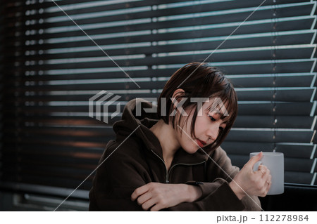 部屋着でソファーに座ってスマホを見る女性 部屋着でソファーに座ってスマホを見る女性 112278984